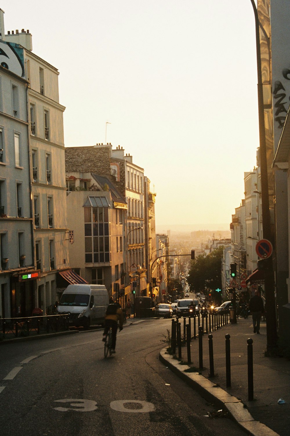 a man riding a bike down a street next to tall buildings