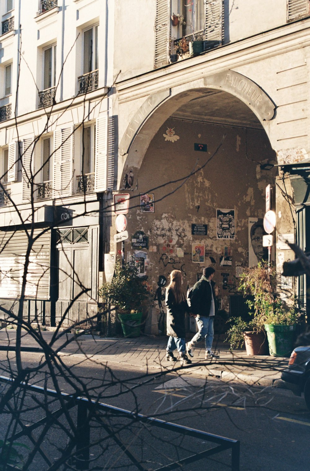 a couple of people that are walking in front of a building