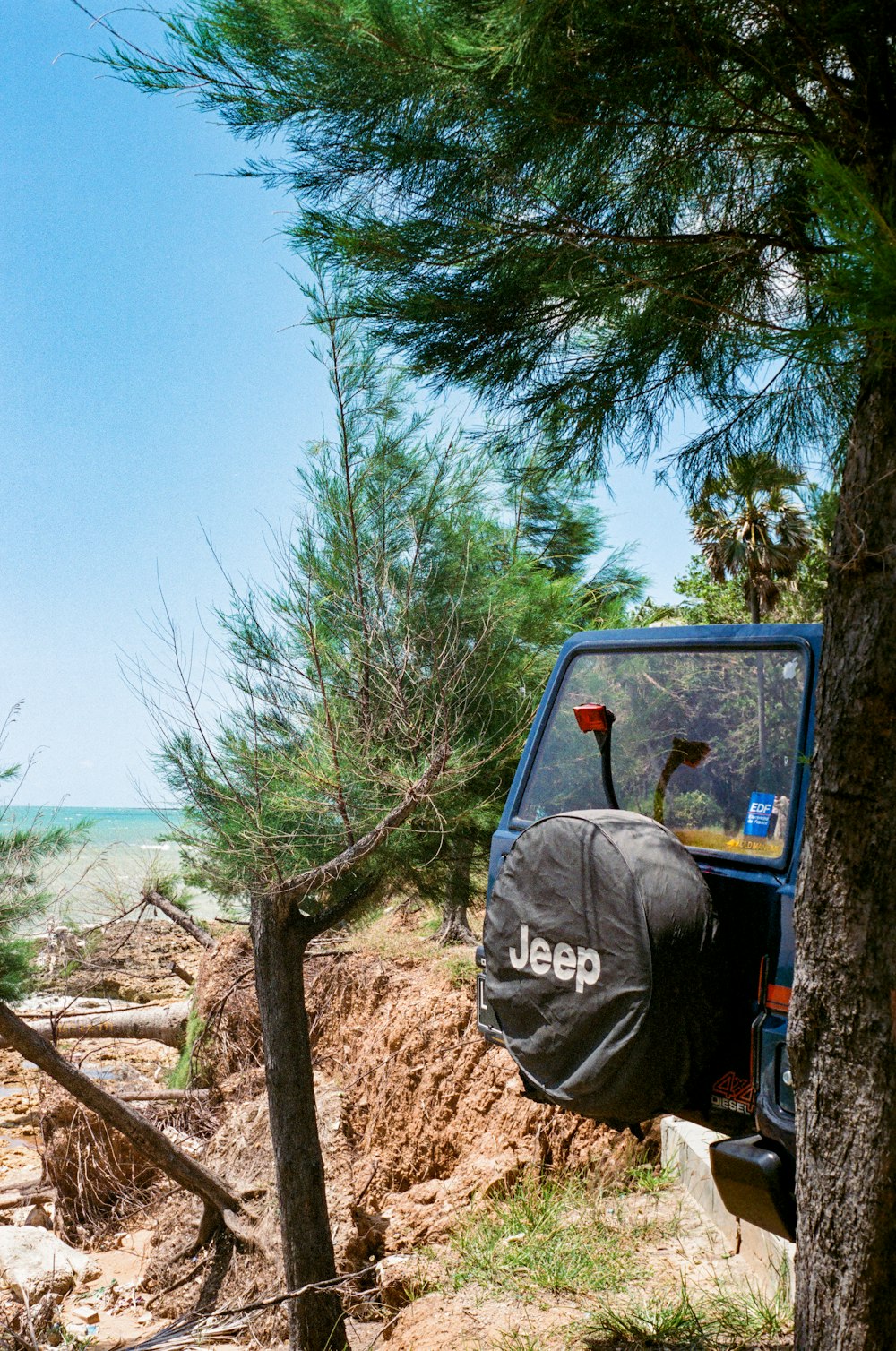 a jeep parked on the side of a dirt road