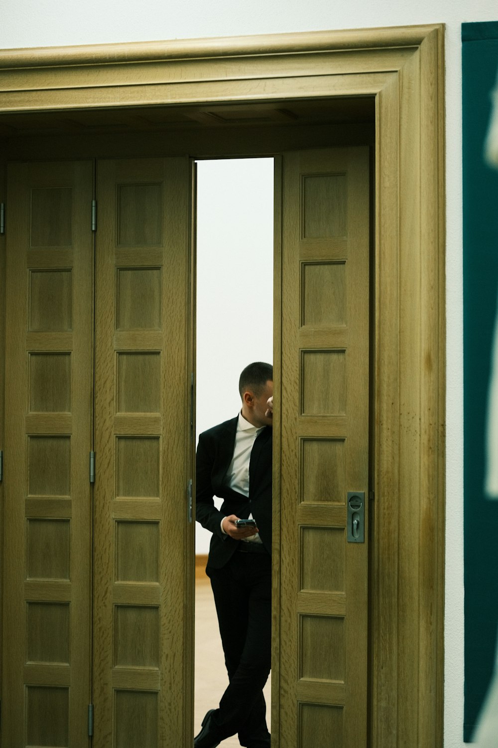 Un hombre con traje parado en una puerta