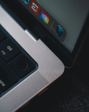 Close-up of hands on a laptop keyboard with a screen showing deleted emails and files.