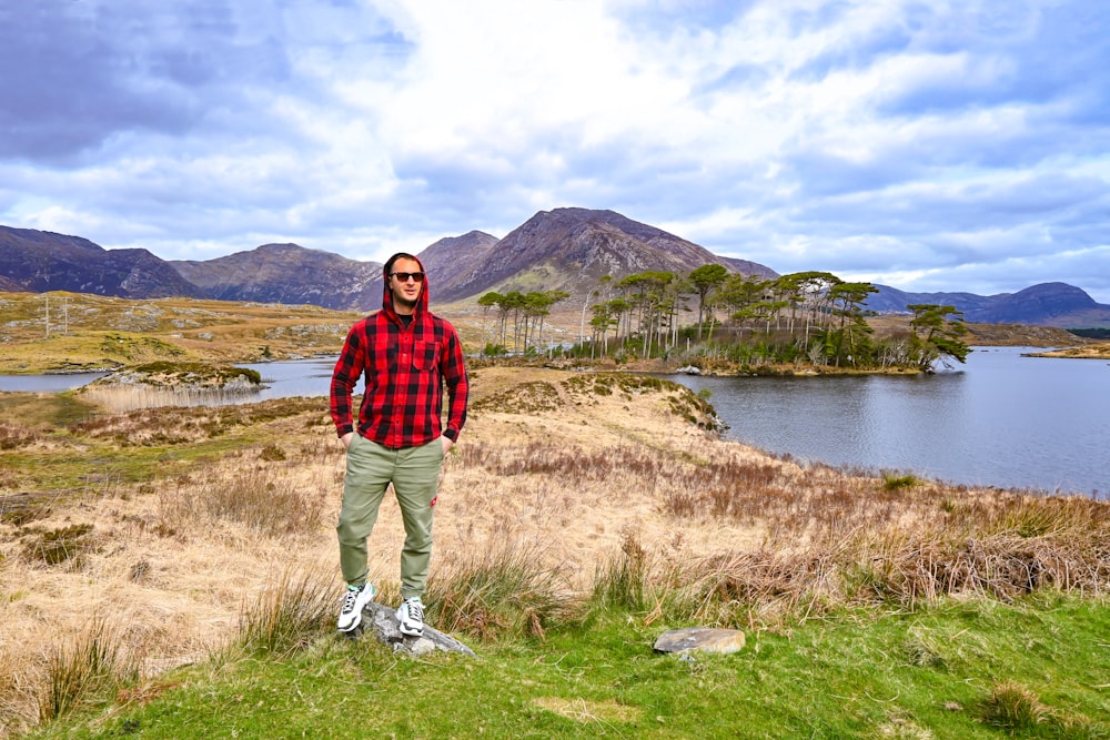 a man standing on top of a grass covered field