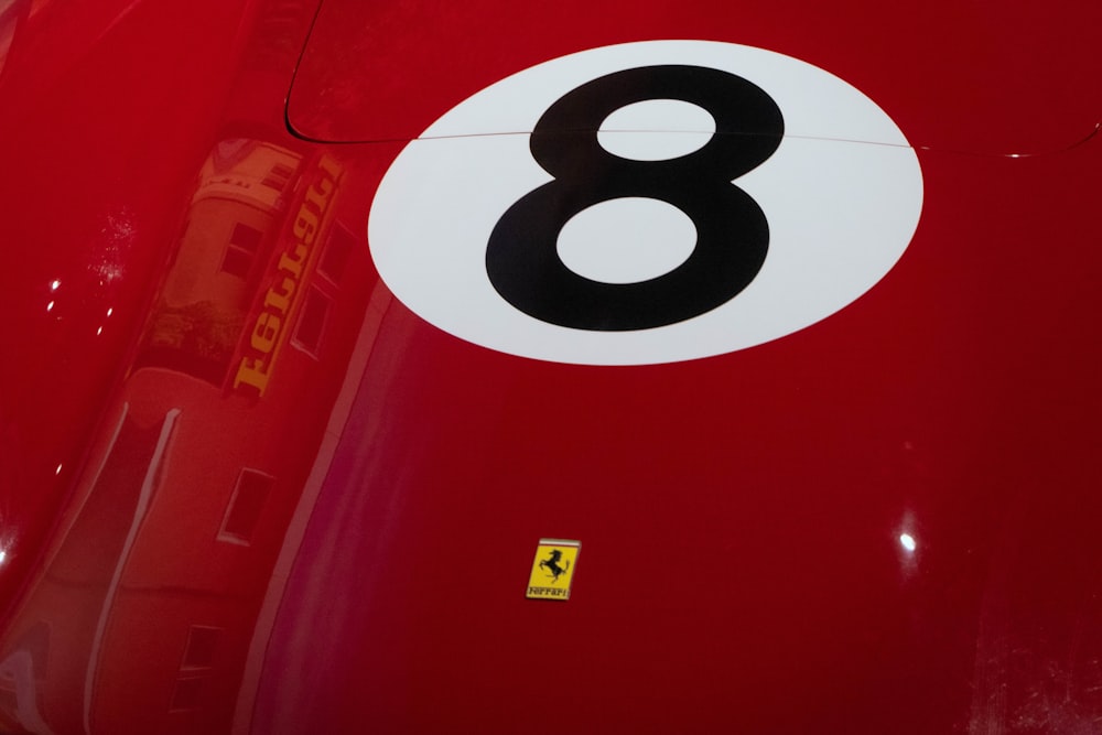 um close up do número oito em um carro esportivo vermelho