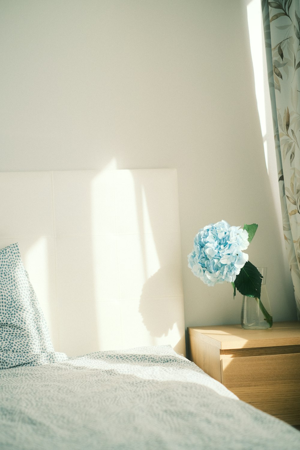a bedroom with a bed and a vase with flowers
