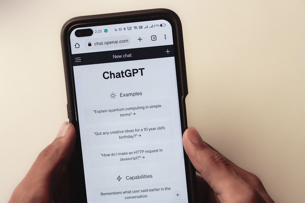 eine Person, die ein Mobiltelefon mit einer Chat-App auf dem Bildschirm hält