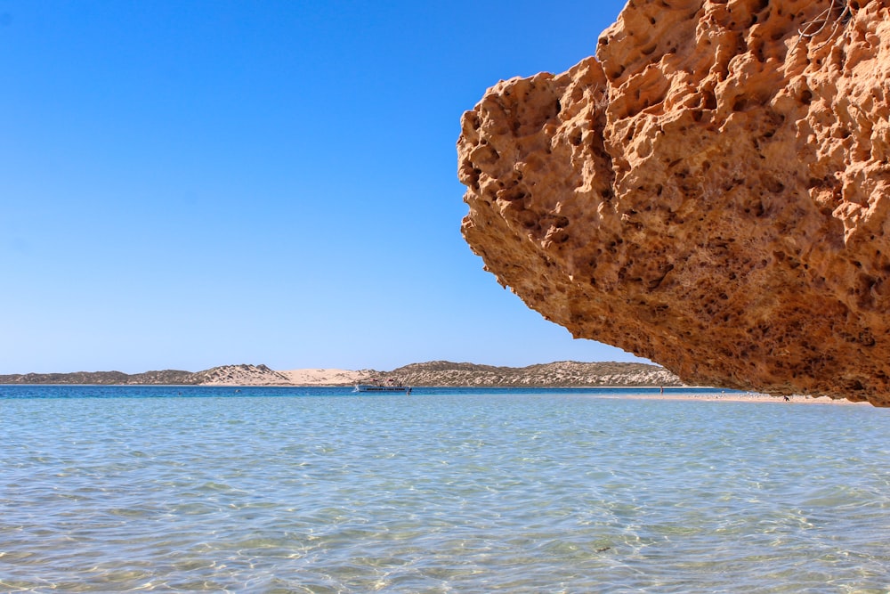 a large rock sticking out of a body of water