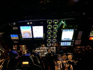 Close-up of a cockpit dashboard illuminated during a night airshow.
