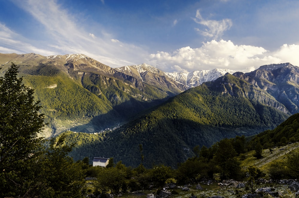 a view of a mountain range with a house in the foreground