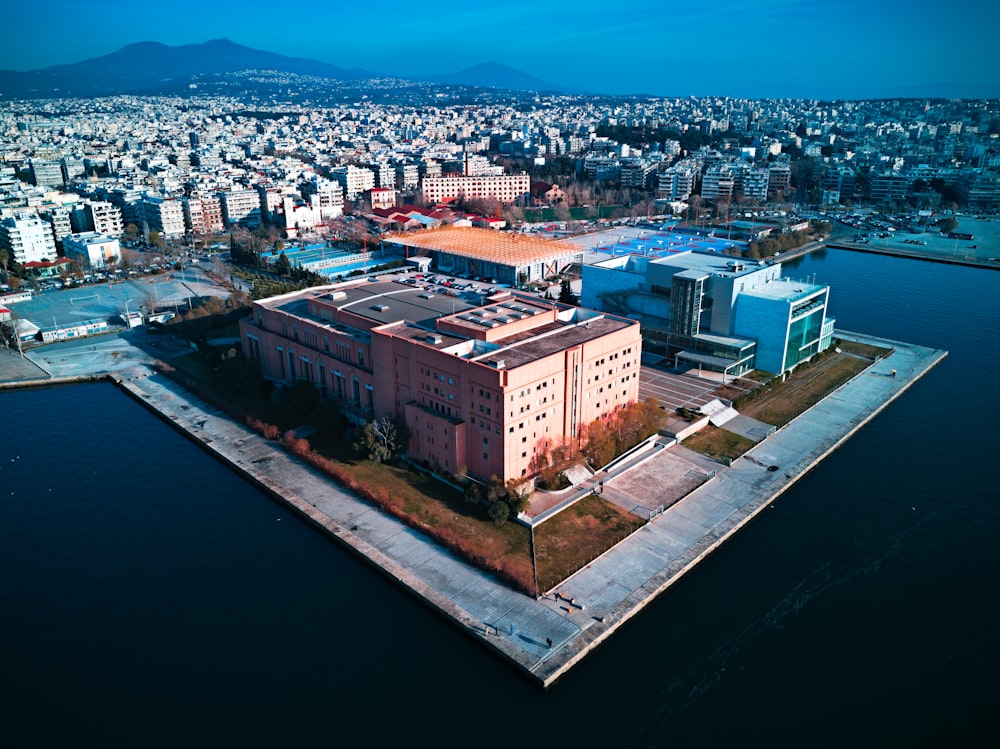 an aerial view of a large building next to a body of water