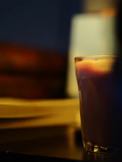 A warm, softly lit scene showing a finished glass beside a poured drink, ready to be enjoyed