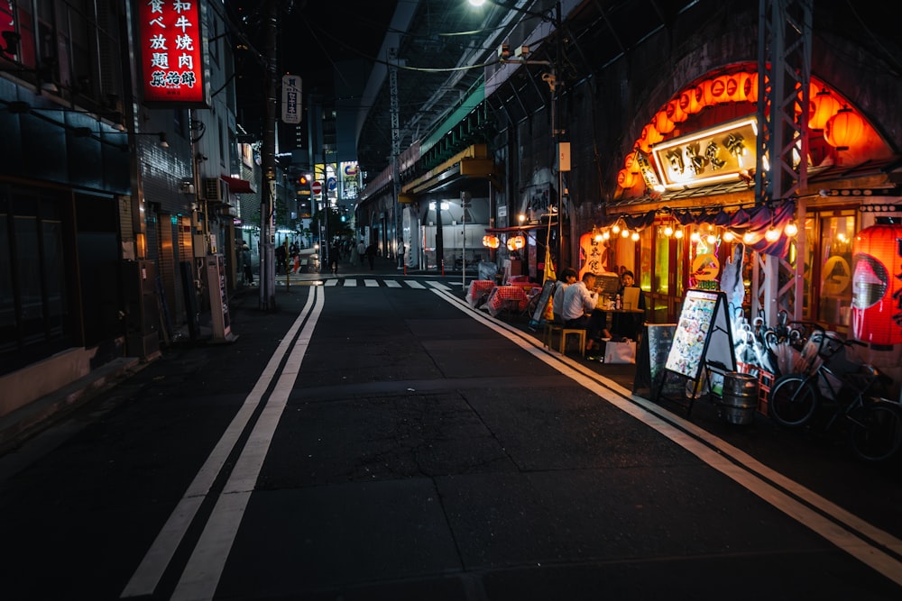 a dark alley with a food stand at night
