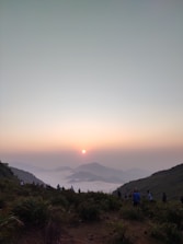 Sunset view over a mountain ridge with trekkers resting and enjoying the moment.