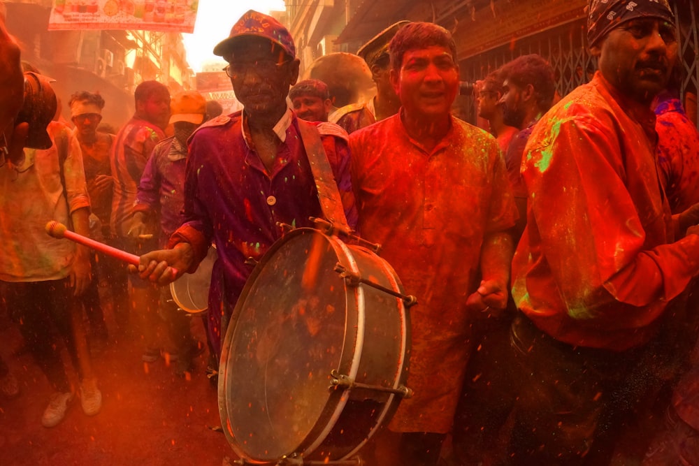 a group of men standing around a drum on a street