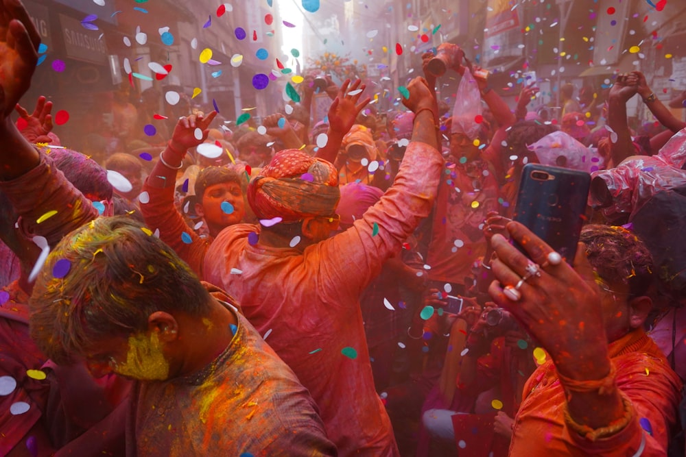 a group of people celebrating with colored powder and confetti