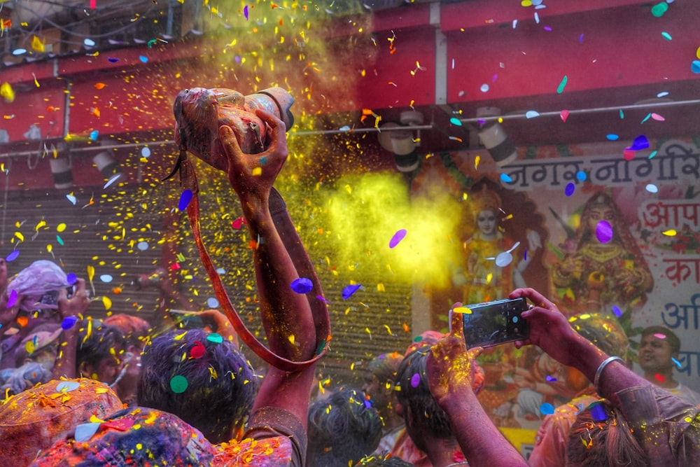 a group of people celebrating with colored powder and confetti