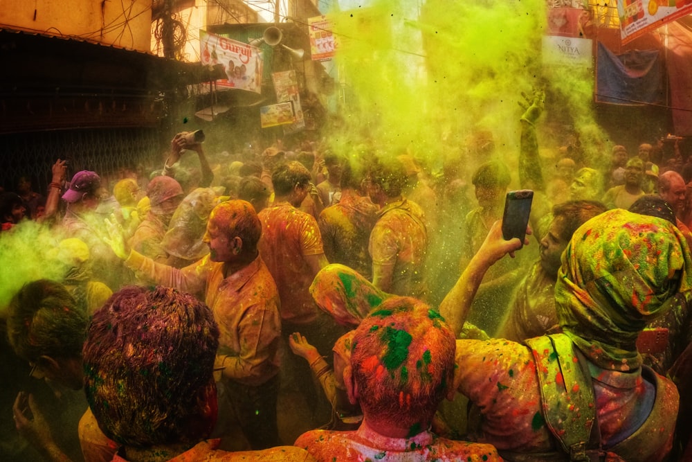 uma multidão de pessoas cobertas de pó colorido