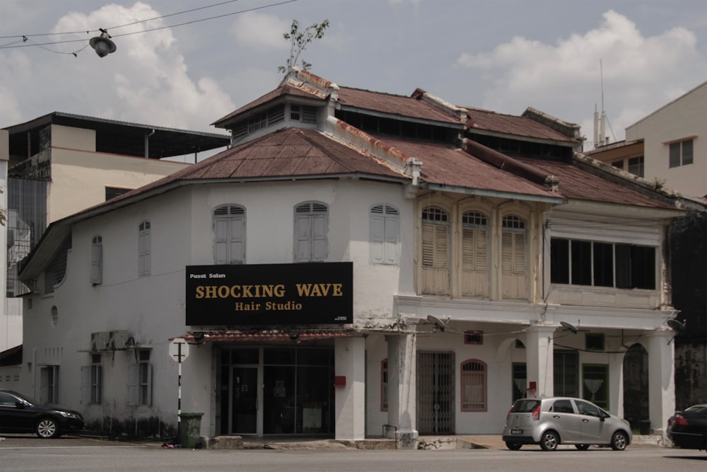 a white building with a sign that says shocking wave hair studio