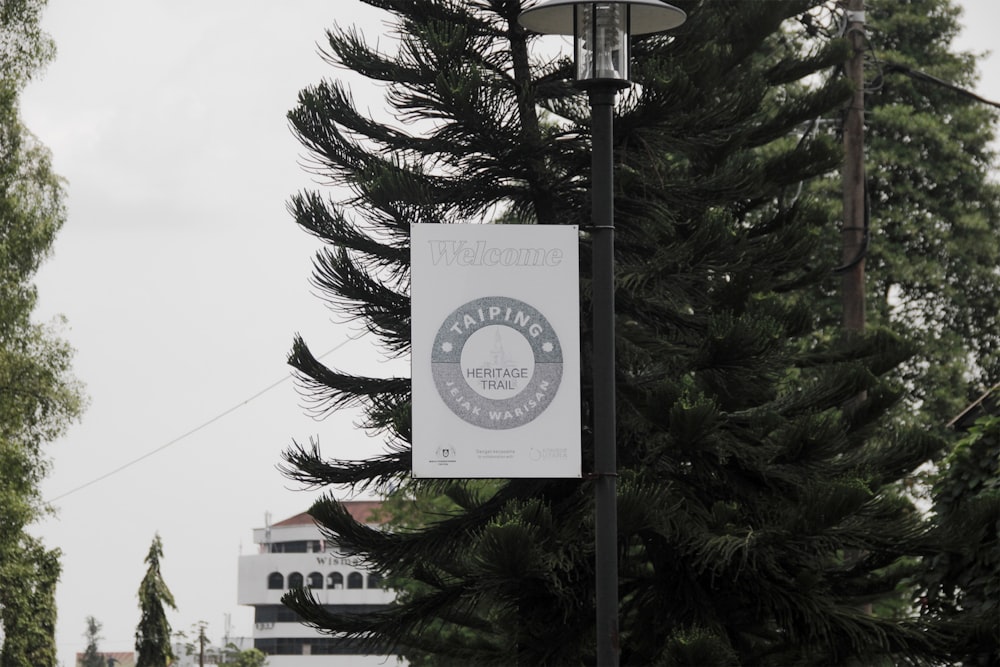 a street light with a sign hanging from it's side