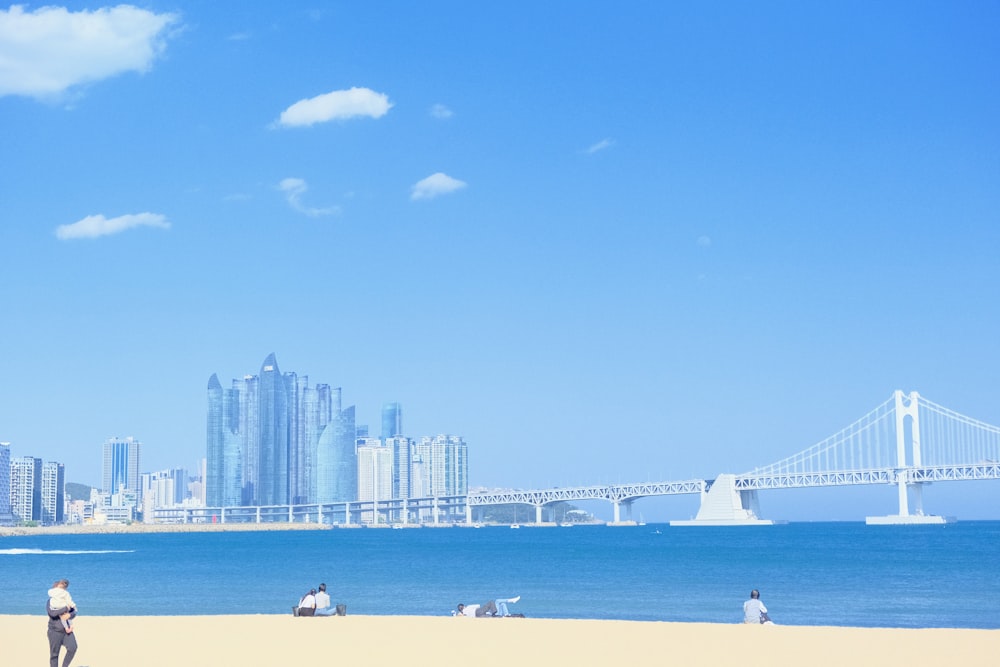 a group of people standing on top of a sandy beach