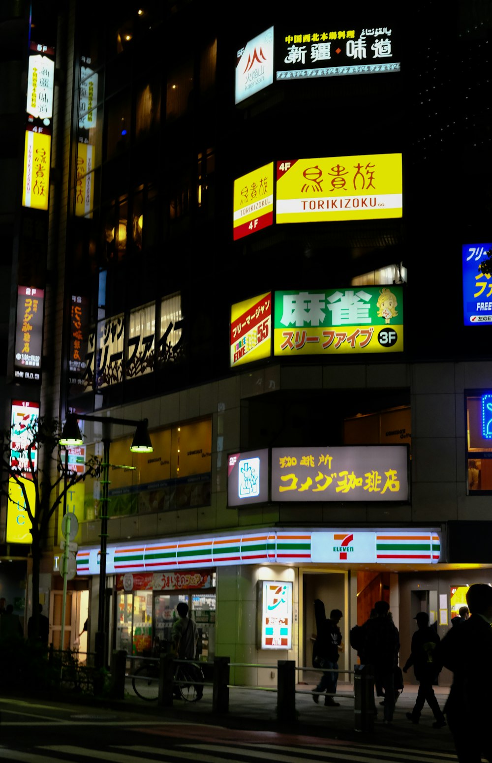 a group of people walking down a street at night