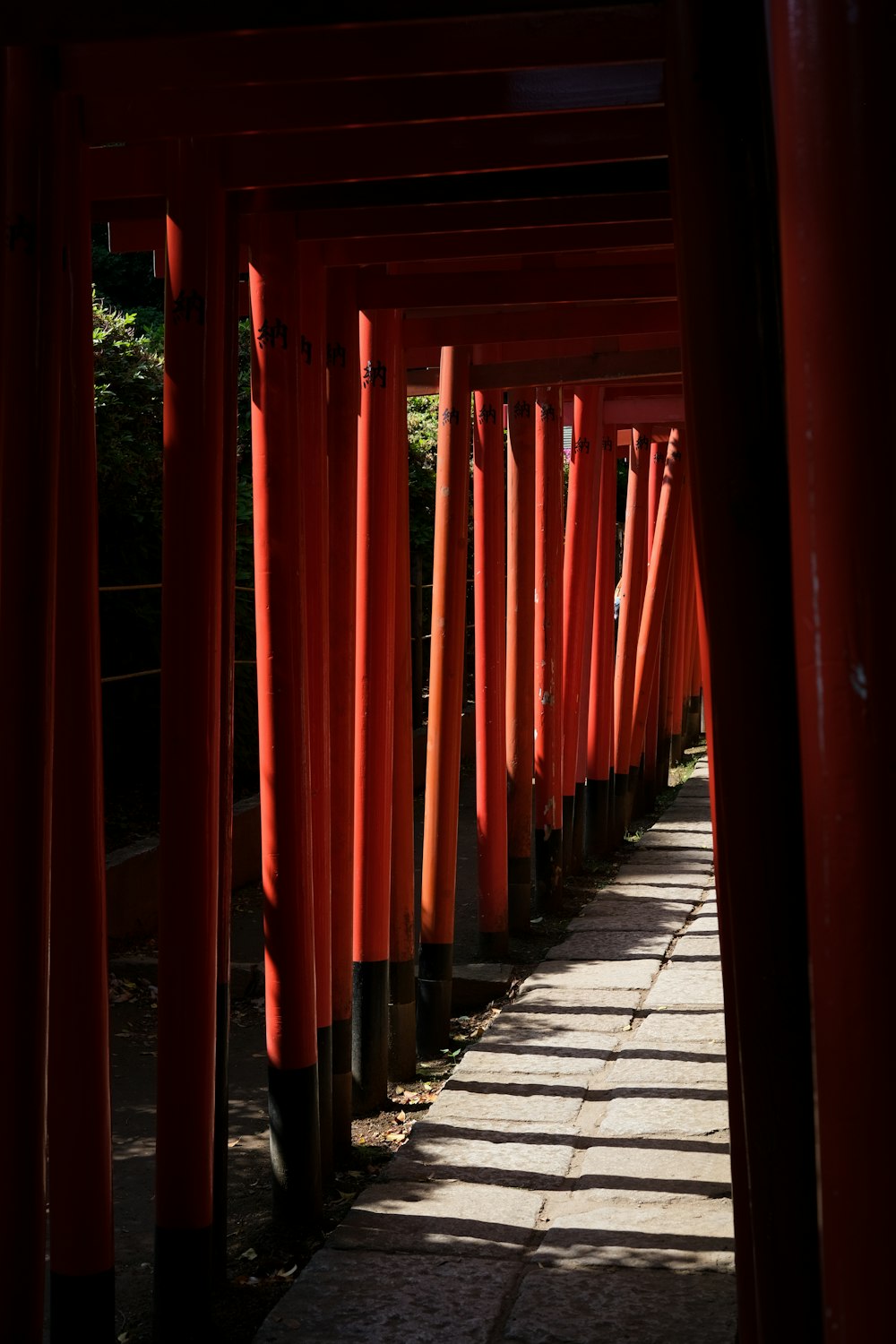 a row of red pillars in the middle of a walkway