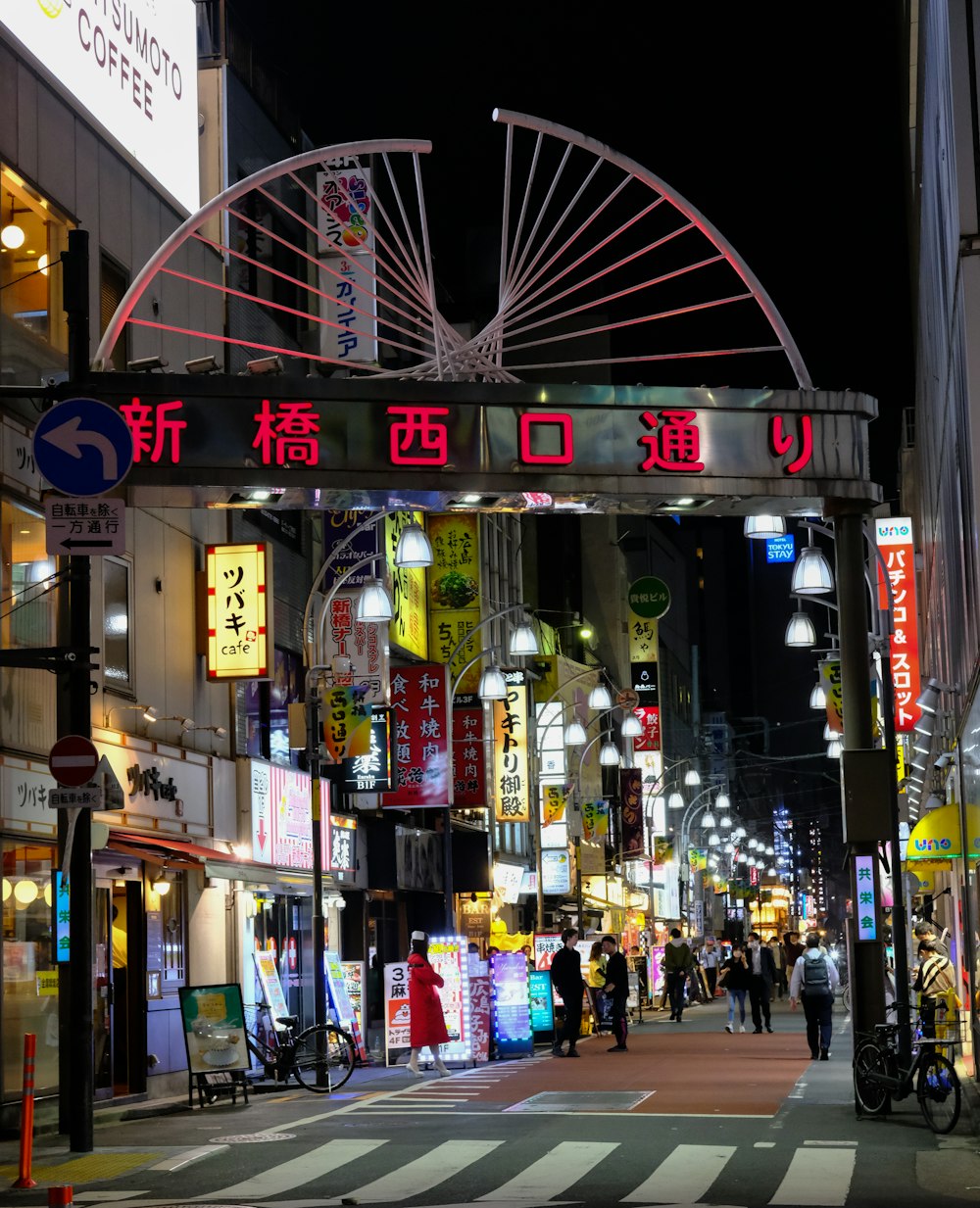 Una strada della città di notte con una ruota panoramica sullo sfondo