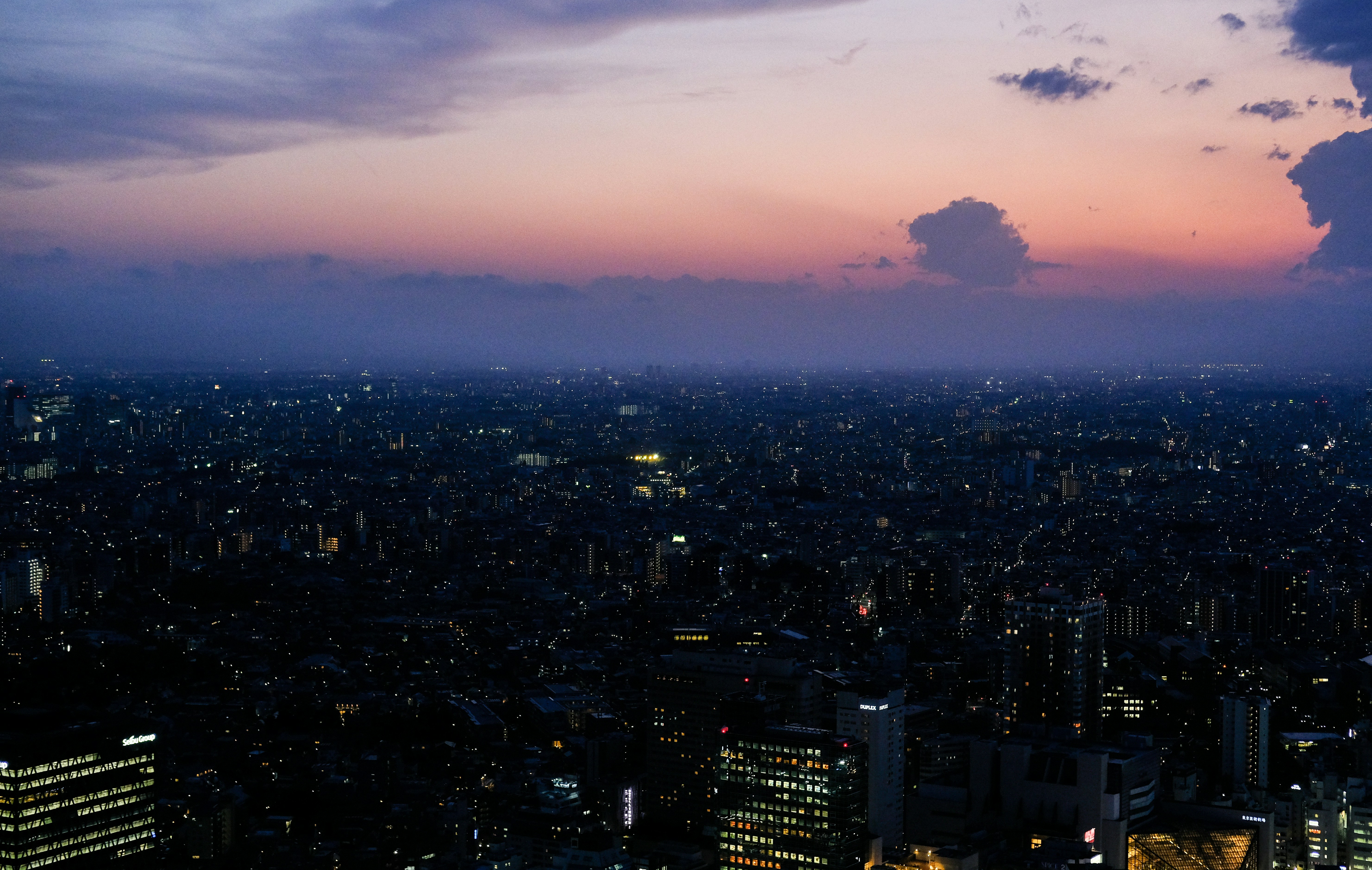 a view of a city at night from the top of a building, 