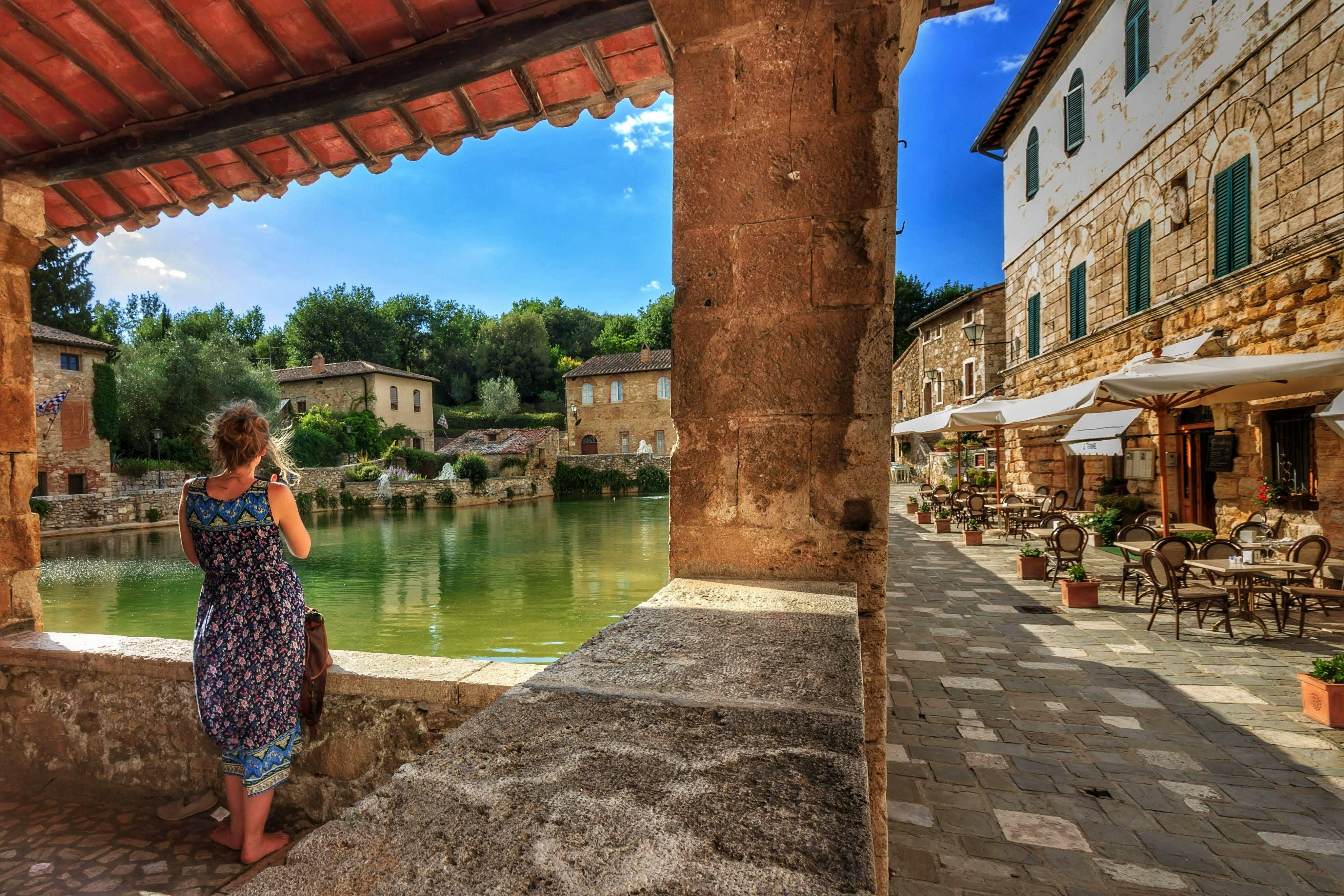 a woman standing on a stone walkway next to a river