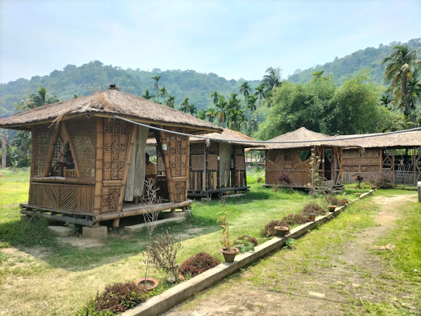 Cozy bamboo bungalow surrounded by tropical plants at the wellness retreat.