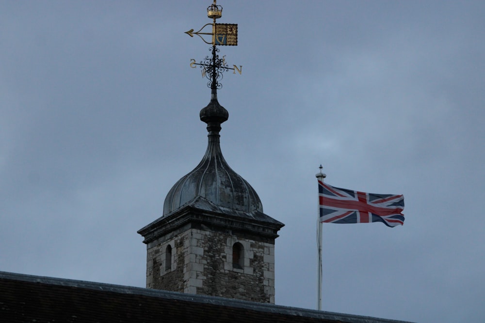 una torre con un reloj y una bandera encima