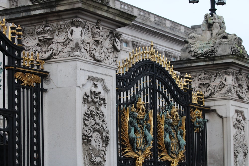 a black and gold gate with statues on it