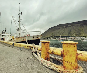 Portrait of a local fisherman against a backdrop of a weathered boat at the dock.