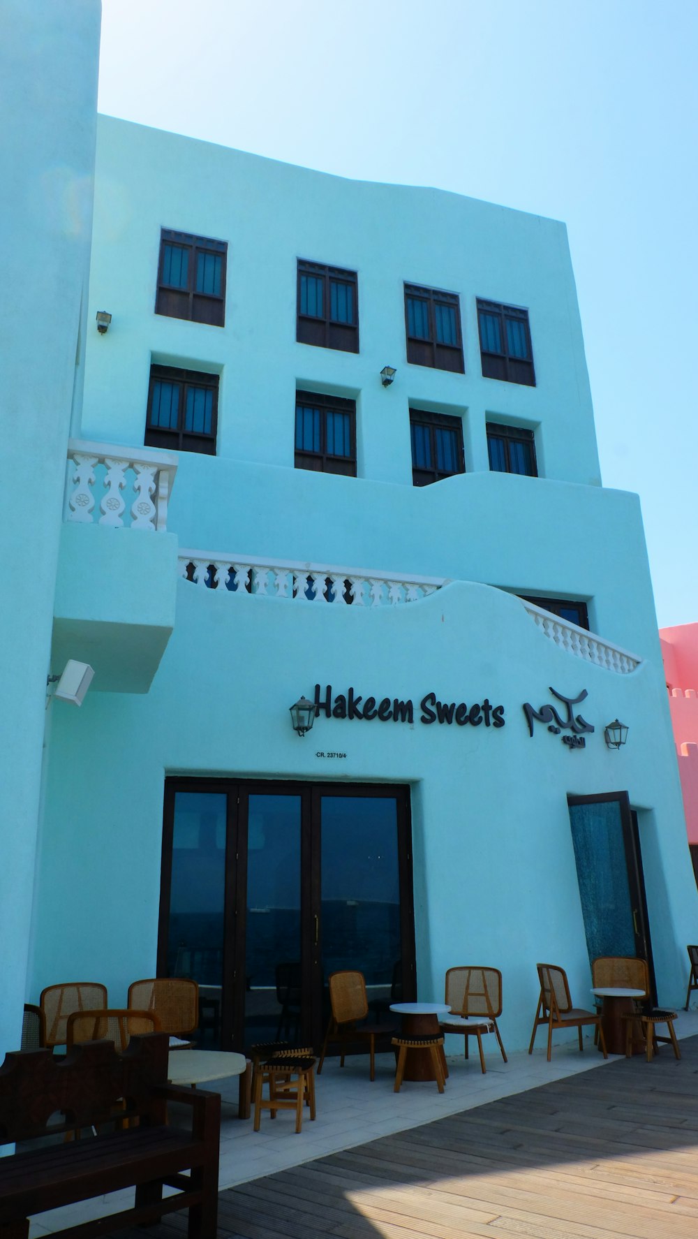 a white building with tables and chairs outside of it