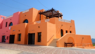 an orange building with a wooden bench in front of it