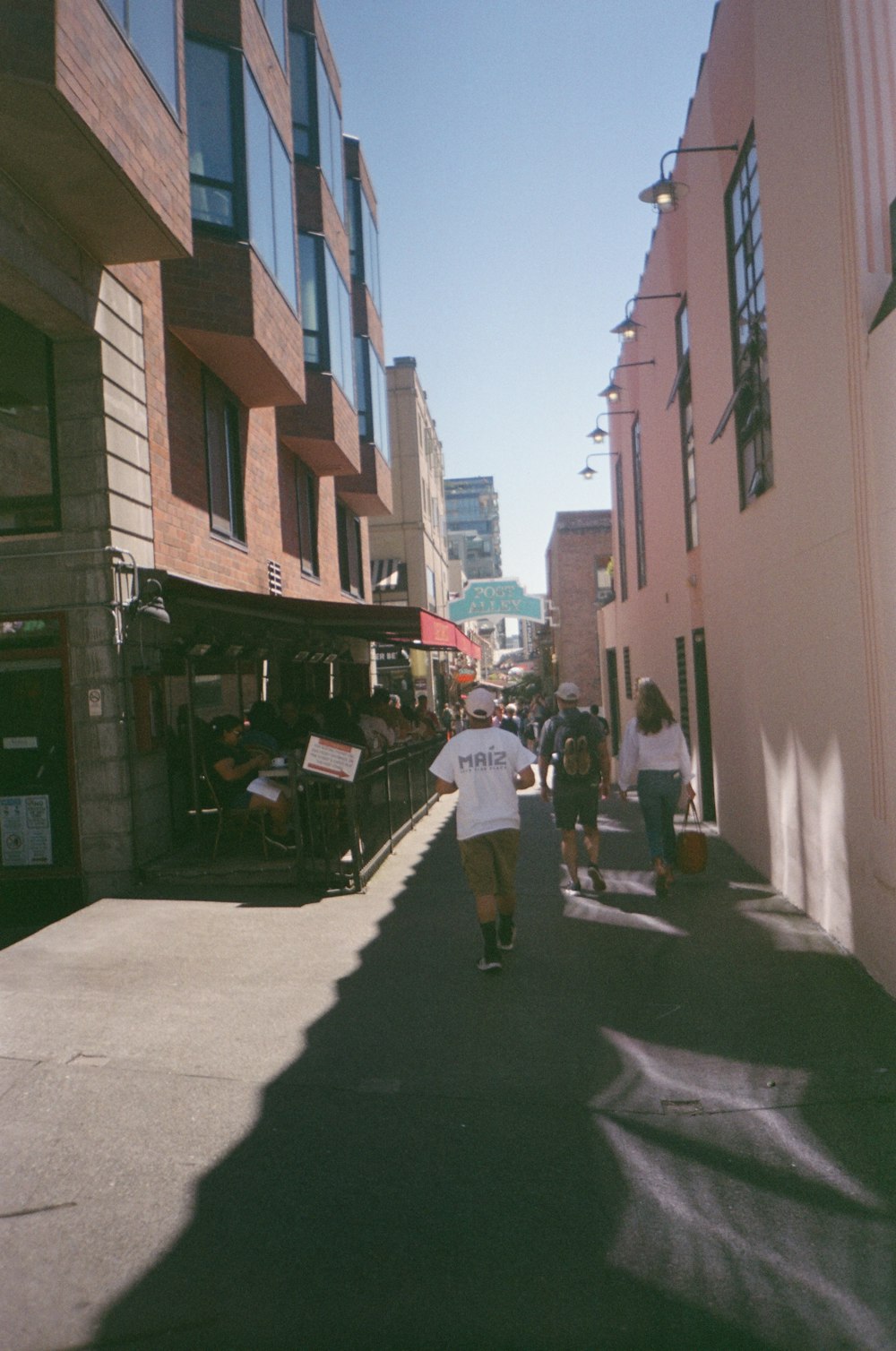 a man walking down a street next to tall buildings