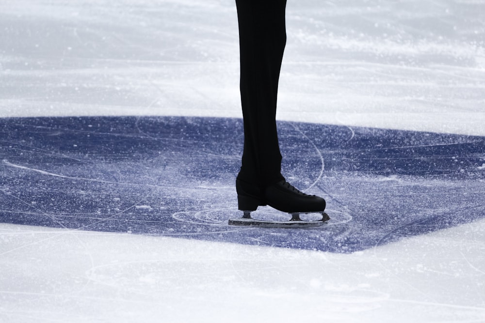 a person's feet on a skate on an ice rink