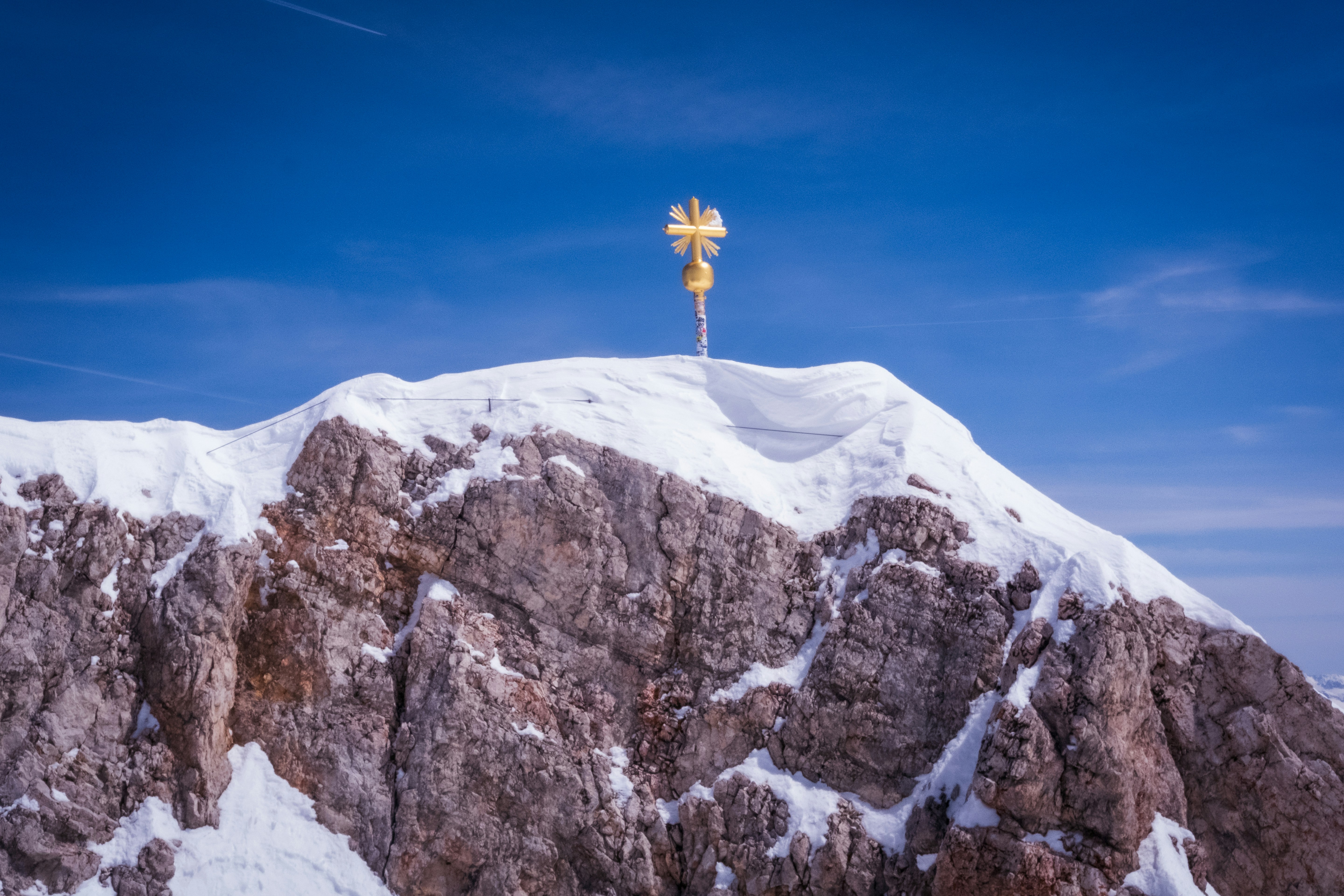 a cross on top of a mountain covered in snow