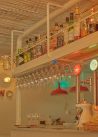 Bar counter showcasing bottles of artisanal vermut and wine with glasses ready to be served.