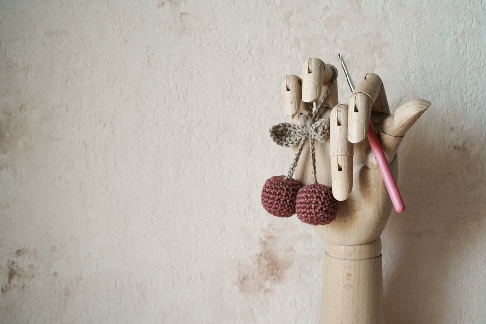 a wooden hand holding a pair of scissors