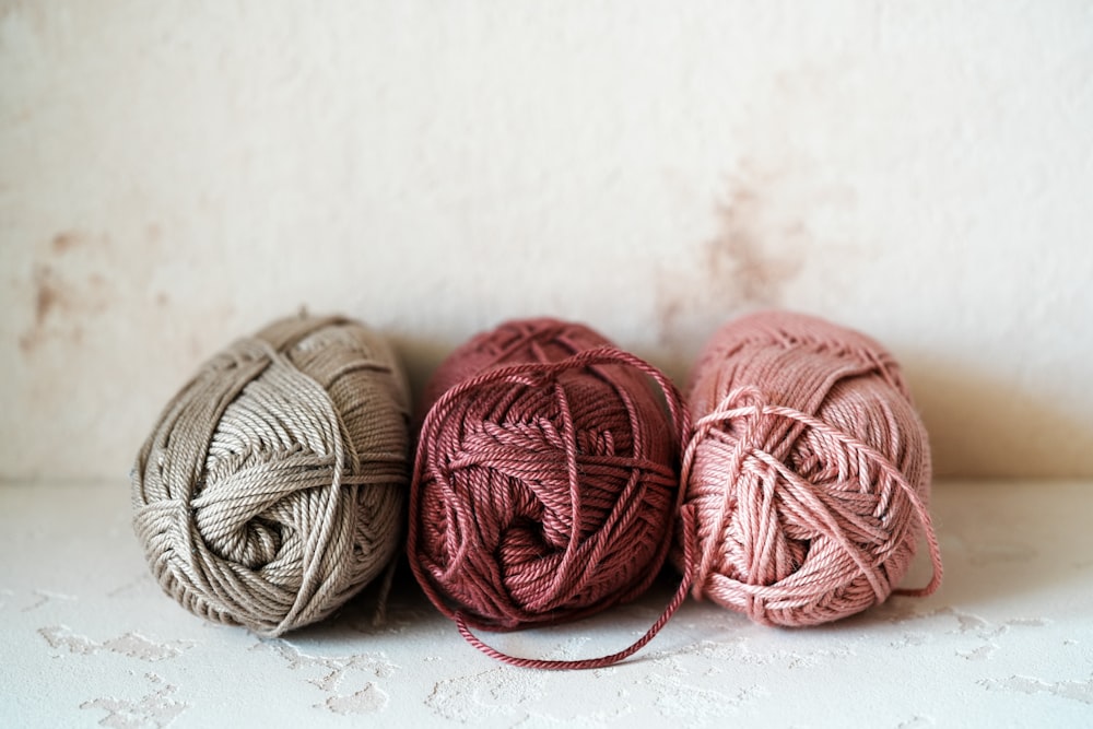 three balls of yarn sitting on top of a table