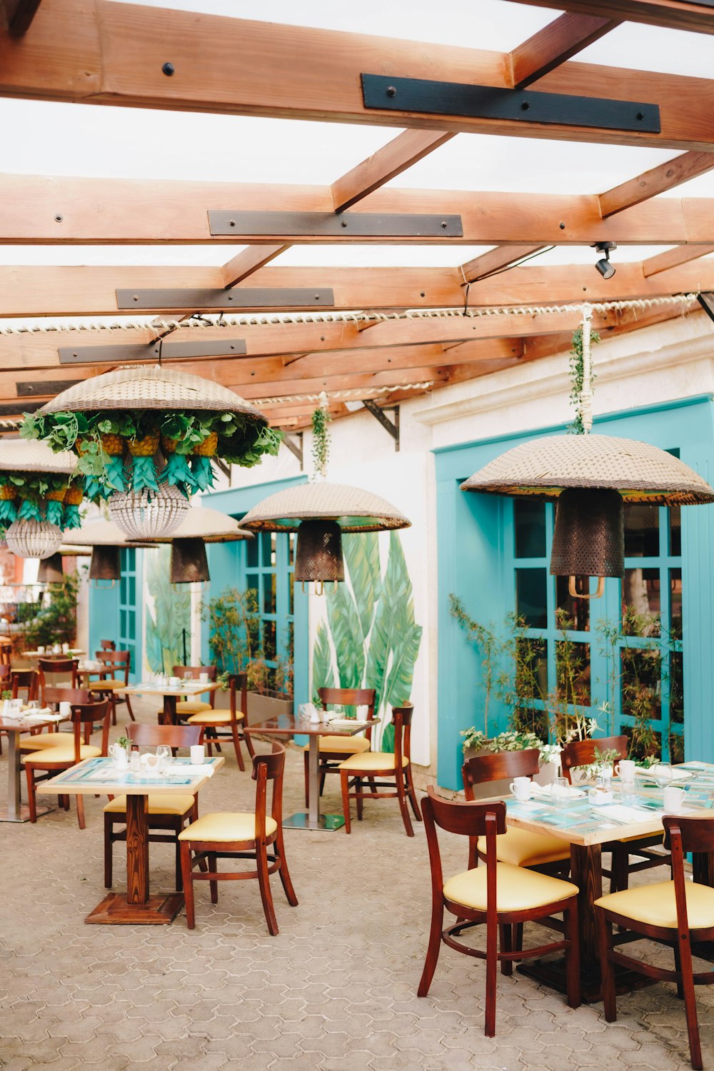 a restaurant with tables, chairs and umbrellas