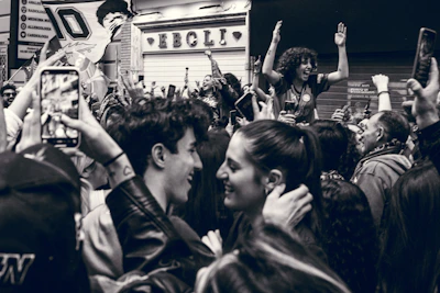 A lively crowd gathered at an open-air stage celebrating Delta Independence Day with flags waving and colorful decorations.