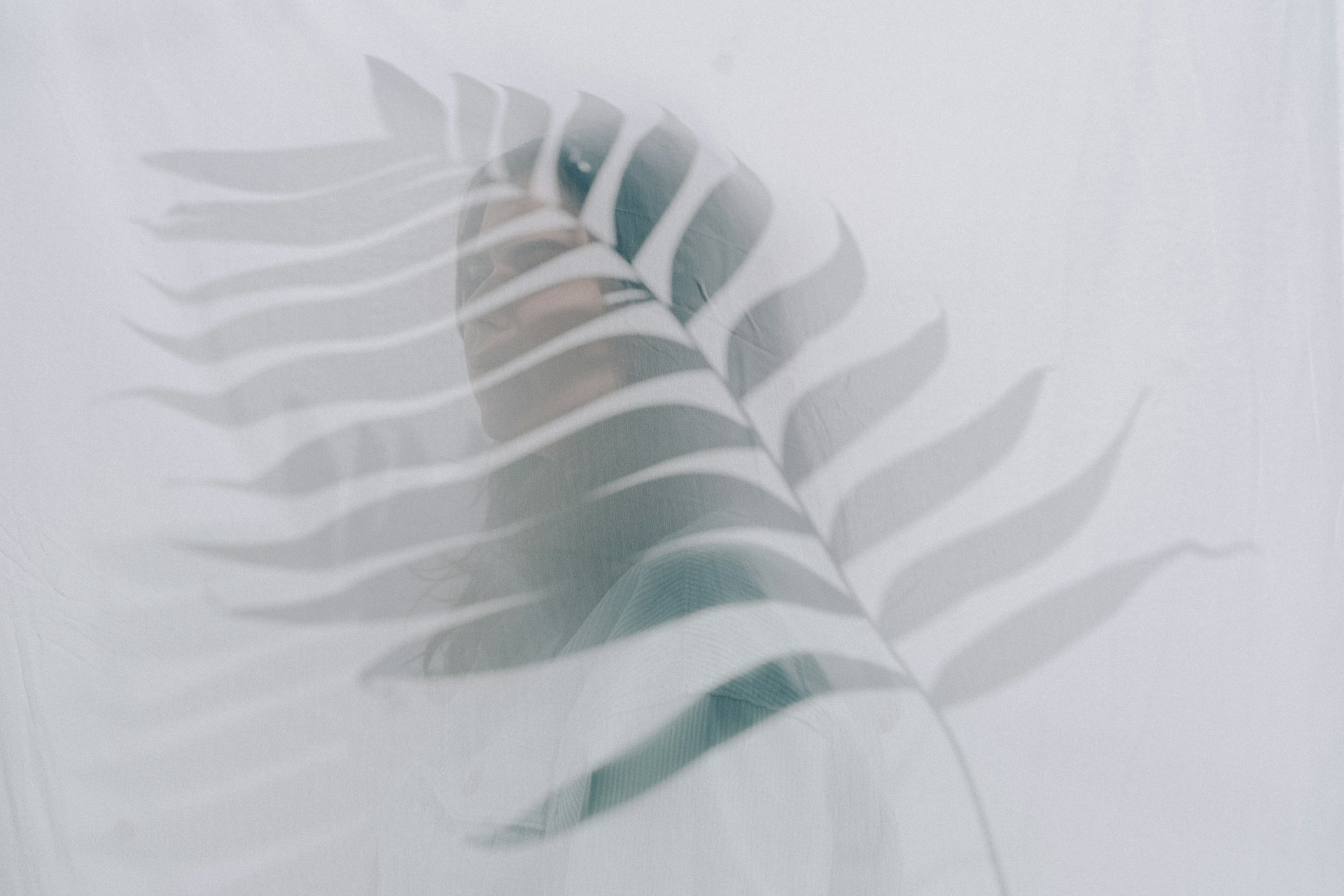 A delicate, ghostly figure fading into a backdrop of swirling autumn leaves, capturing a haunting, intimate mood.