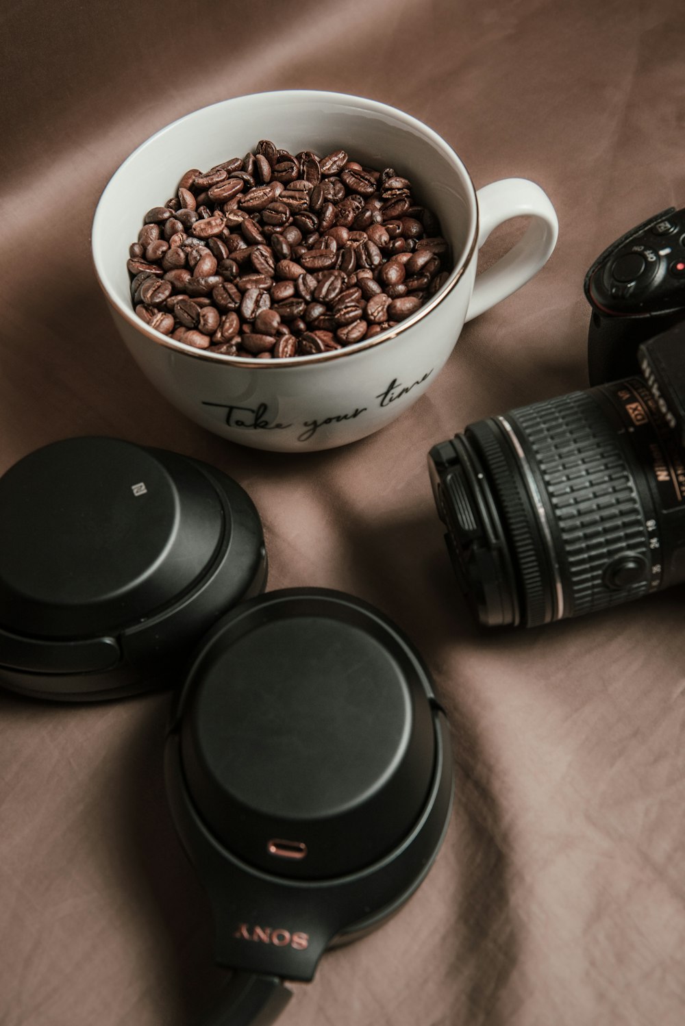 uma câmera e alguns grãos de café em uma mesa