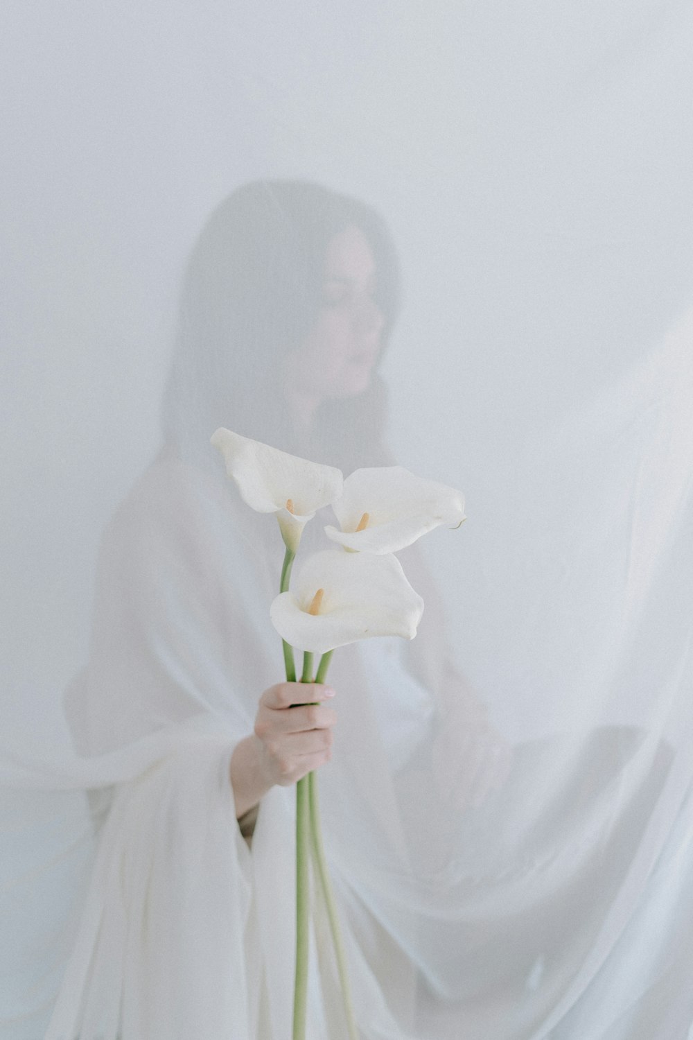 a woman in a white dress holding a white flower