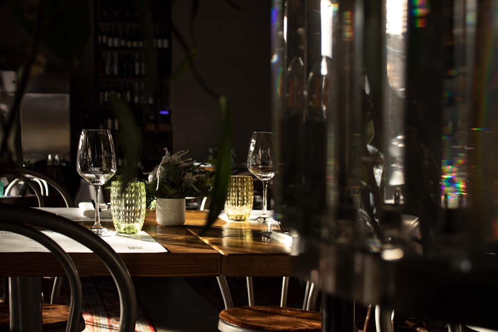 a table with a vase of flowers and wine glasses on it