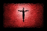 Close-up of a red and black Christian-themed sublimated t-shirt with a bold cross design.