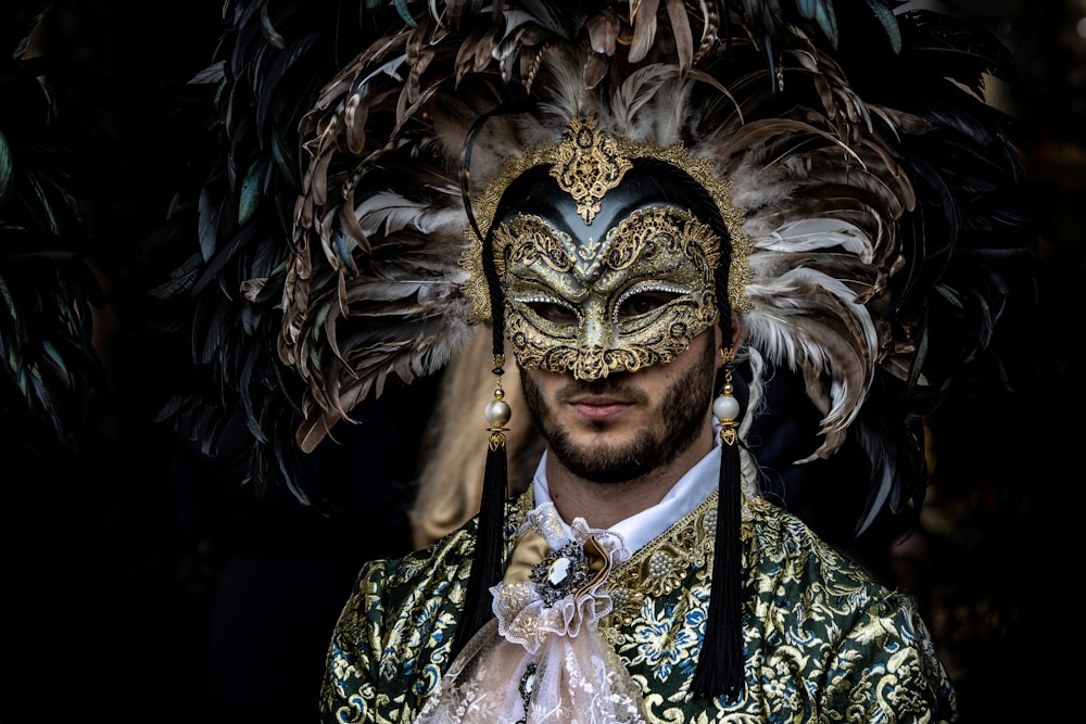 a man wearing a mask with feathers on his head