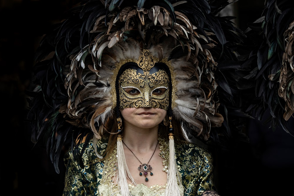 a woman wearing a mask with feathers on her head