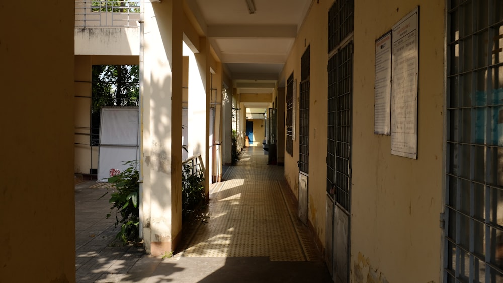 a long hallway leading to a building with lots of windows